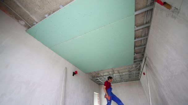 Mannen controleren de nauwkeurigheid van het installatie frame voor opgehangen plafond — Stockvideo