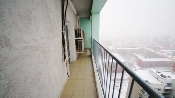 Balkon en vele gebouwen in besneeuwde winterdag met blizzard — Stockvideo