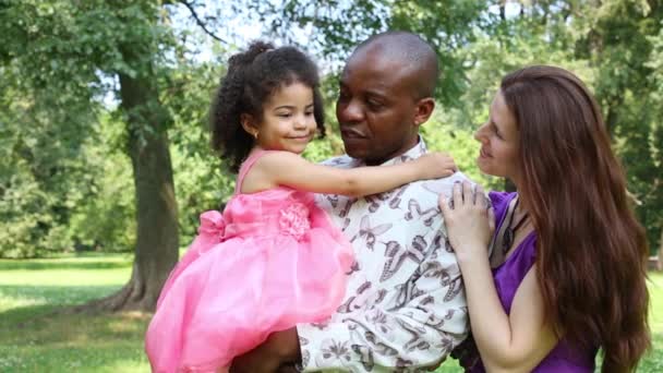 Padre sostiene a la hija en las manos, la madre se queda parada y abraza — Vídeos de Stock