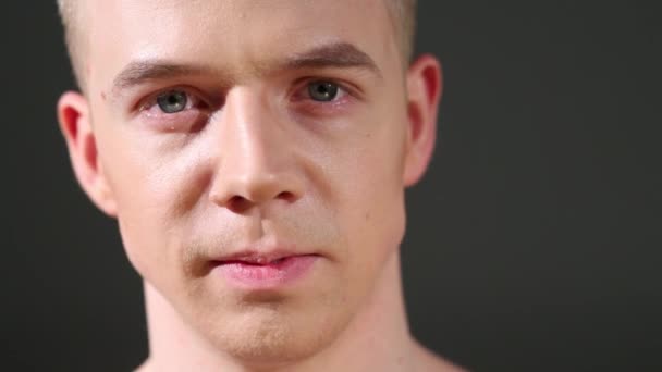 Közelről portréja szép fej-fordítás ember a szürke háttér — Stock videók
