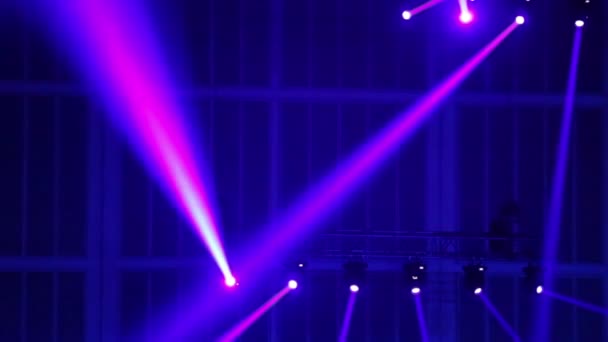 Rayos violetas de proyectores en el techo se mueven en círculo — Vídeo de stock
