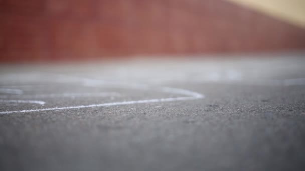Nohy dívka skákání panáka na asfaltu. Mělké dof — Stock video