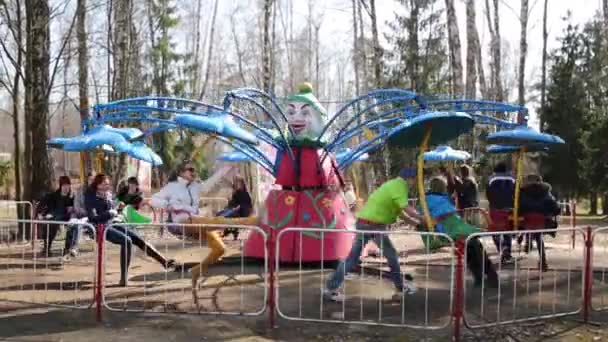 Les adolescents montent sur le carrousel dans le parc du centre de réadaptation Bugorok — Video