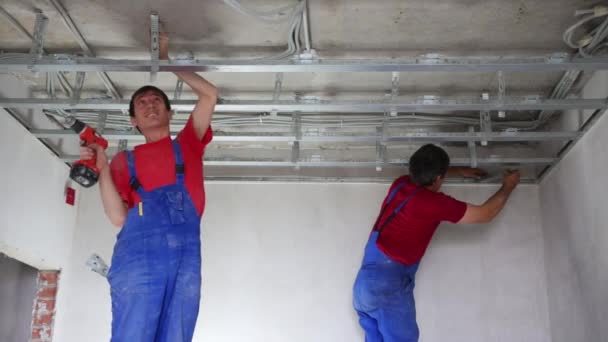 Twee mannen installeren kader voor plafond — Stockvideo