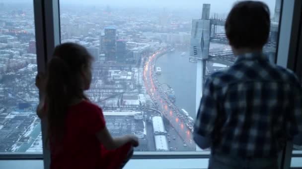 Madre e figli che guardano attraverso la finestra — Video Stock