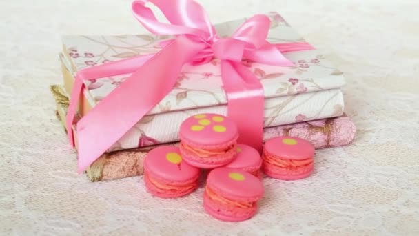 Rose macaroons on table with books — Stock Video