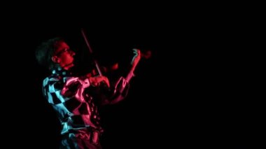 Kostümlü genç kemancı müzik çalıyor. 