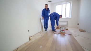 İşçi floorboard üzerinde tutkal smear
