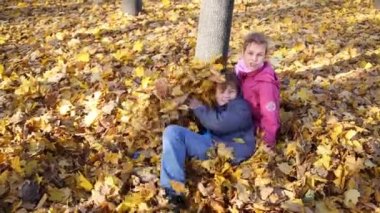 Kız ve erkek sarı yapraklar üzerinde yalan