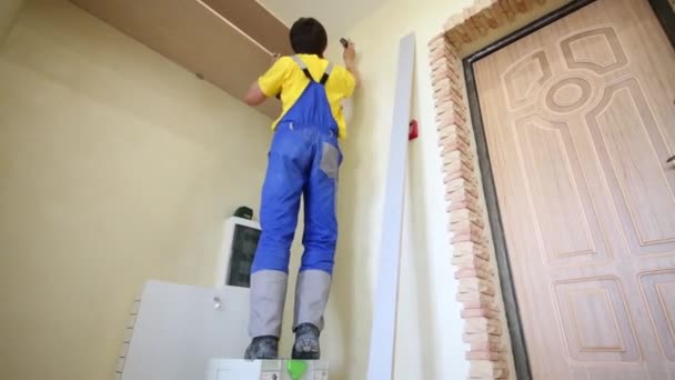 Man maakt merken op muur — Stockvideo