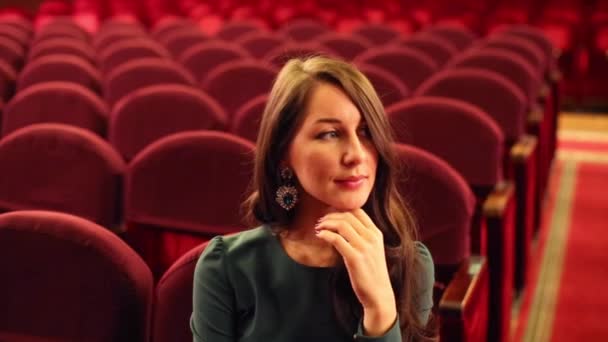 Woman in dress sitting in auditorium in theatre — Wideo stockowe