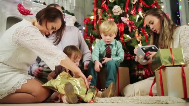 家族がクリスマス ツリーの近くに座っています。 — ストック動画