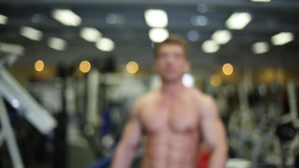 Bodybuilder-Mann geht in Turnhalle. — Stockvideo