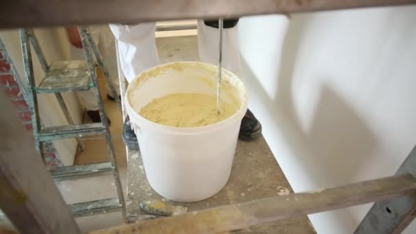 Werknemer in witte uniform mengen stucwerk — Stockvideo