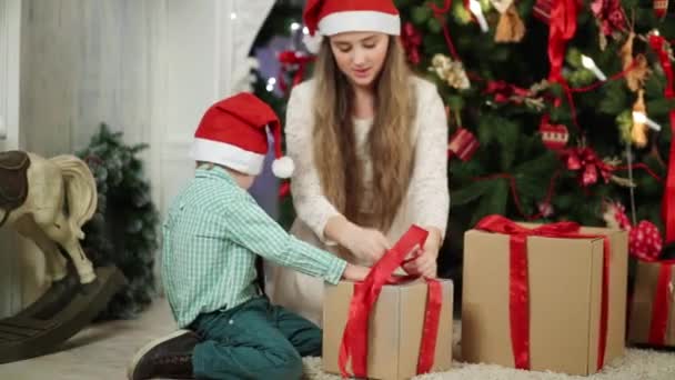 Chica y niño cerca del árbol de Navidad — Vídeos de Stock