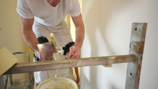 Bâtisseur sur échafaudage inflige plâtre au mur — Video