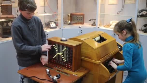 Boy and girl touch old telephones — Stock Video