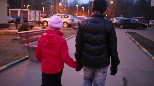 Niño y niña tomados de la mano y caminando — Vídeos de Stock
