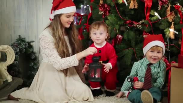Crianças perto da árvore de Natal com lâmpada — Vídeo de Stock
