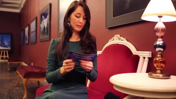 Kadın oturur ve el ilanı alır — Stok video