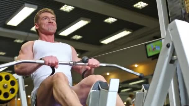 Bodybuilder trains on workout equipment — Stock Video