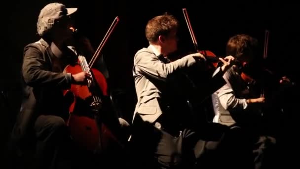 Violinistas con disfraces tocan música en la oscuridad — Vídeo de stock