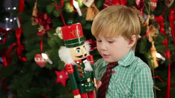 Маленький милый мальчик возле рождественской елки — стоковое видео