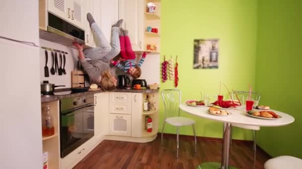 Madre e hija en cocina de casa invertida — Vídeo de stock