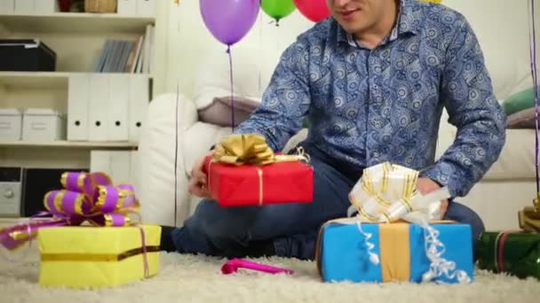 Человек рассматривает подарочные коробки — стоковое видео