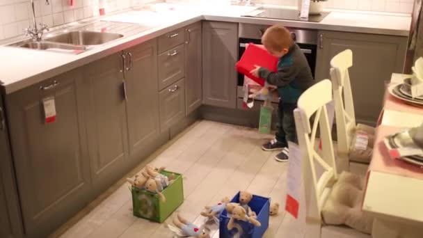 Мальчик играет с игрушками и коробками — стоковое видео