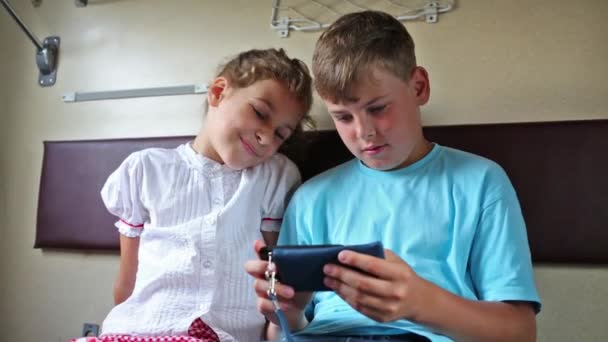 Broer en zus spelen met telefoon — Stockvideo