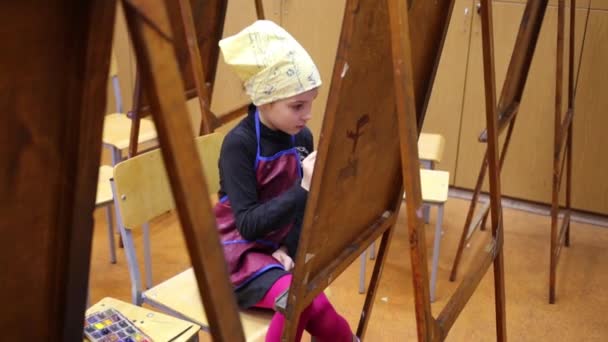Little painter sits in classroom. — Stock Video