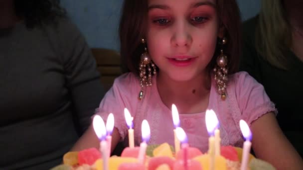 Девушка загадывает желание и задувает свечи — стоковое видео