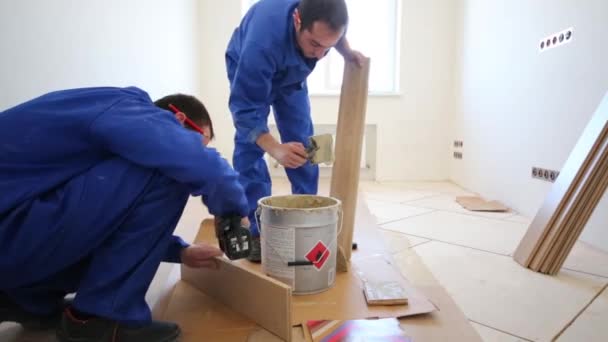 労働者は、床板に接着剤を塗ります — ストック動画