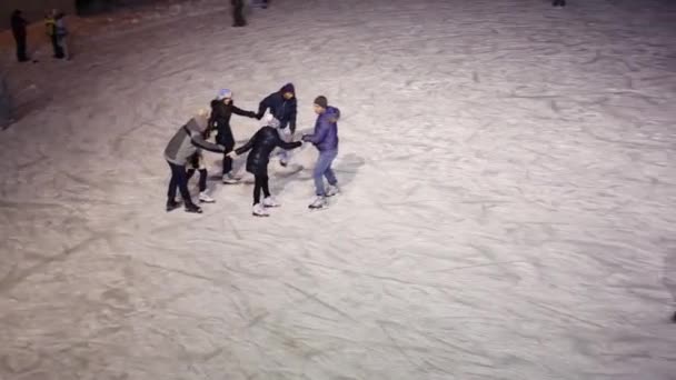 Menschen am Abend auf der Eisbahn — Stockvideo