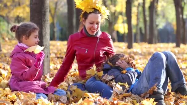 Mutter und Tochter werfen mit Blättern — Stockvideo