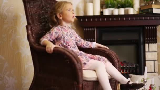 Маленькая девочка в плетеном кресле-качалке — стоковое видео