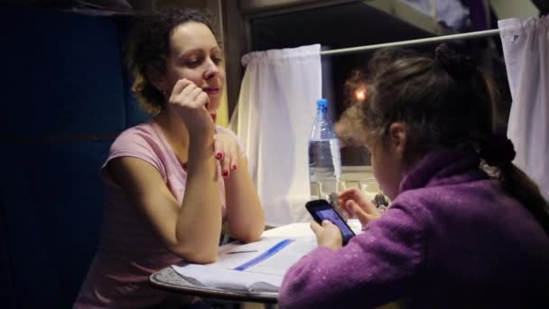 Matka mluví s dcerou v uhánějícím vlaku. — Stock video