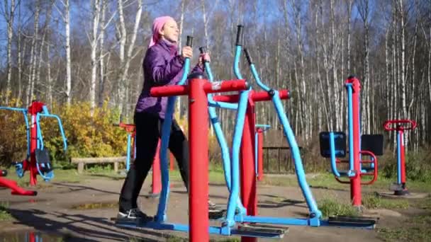 Vrouw doet oefeningen op de simulator van ski — Stockvideo