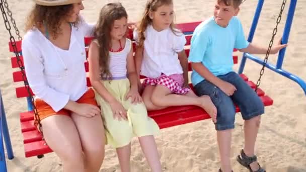 Mladá žena s dětmi na houpačce. — Stock video