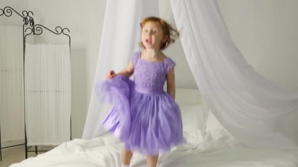 Niña en vestido saltando en la cama — Vídeos de Stock