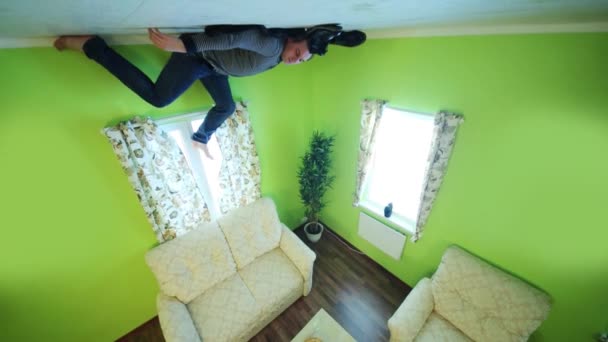 Man in spijkerbroek ligt op plafond — Stockvideo
