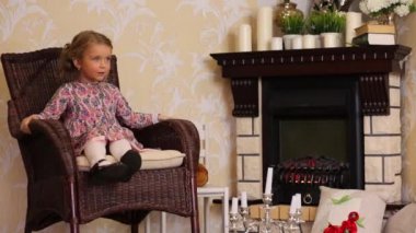 Küçük kız sallanan sandalyede oturur 