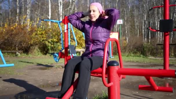 Женщина делает упражнения на тренажере — стоковое видео