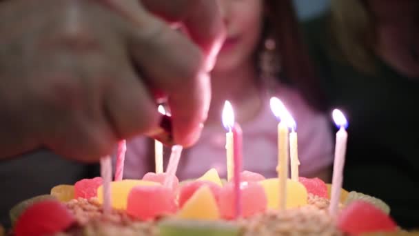 Chica sentarse a la mesa y velas en la torta — Vídeo de stock