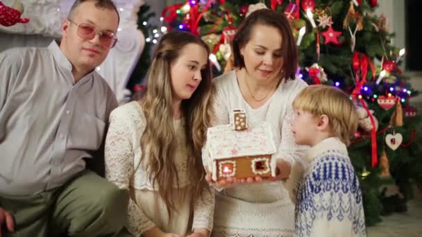 Family looks on gingerbread house — Stock Video