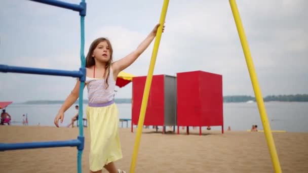 Gadis kecil berputar-putar di taman bermain — Stok Video