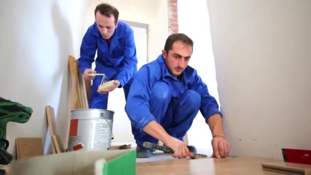 Працівник об'єднує дошки підлогових покриттів — стокове відео
