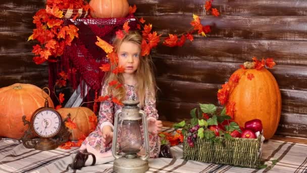 Little girl sits in room with pumpkins — Stock Video