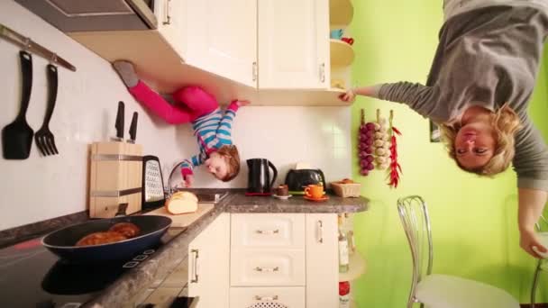 Mother and daughter in kitchen of inverted house — Stock Video